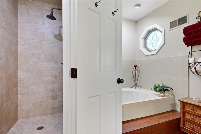 full bathroom with a tile shower, a bath, and vanity