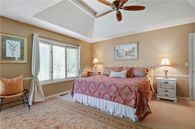 carpeted bedroom featuring baseboards, a textured ceiling, and a ceiling fan