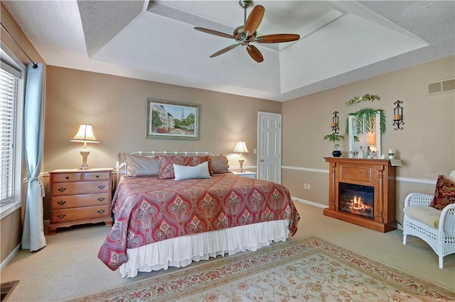 bedroom featuring carpet, multiple windows, and a glass covered fireplace