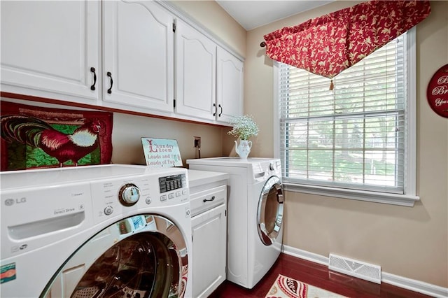 clothes washing area featuring cabinet space, independent washer and dryer, and baseboards