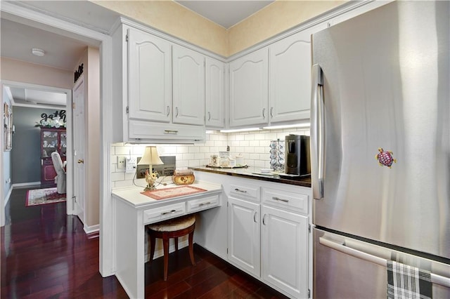 kitchen with freestanding refrigerator, white cabinetry, and dark wood-type flooring