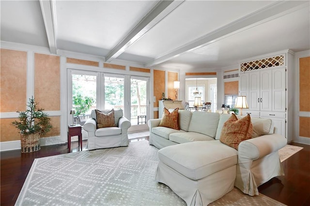 living area with wood finished floors, beamed ceiling, and baseboards