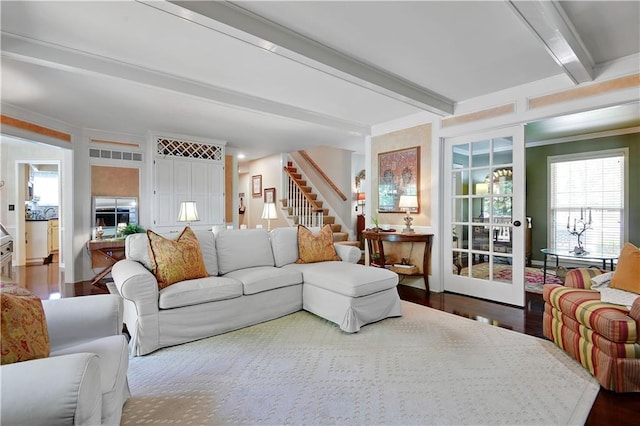 living room with stairs, beamed ceiling, and wood finished floors