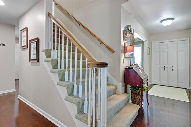 entryway featuring wood finished floors, stairs, and baseboards