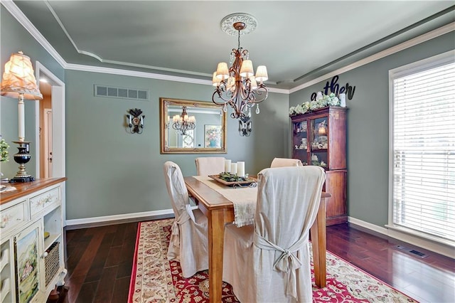 dining area with a chandelier, healthy amount of natural light, wood finished floors, baseboards, and ornamental molding