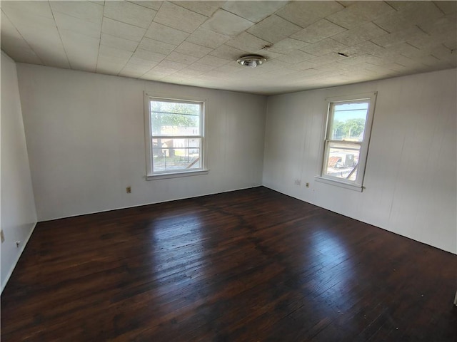 unfurnished room featuring dark wood finished floors and healthy amount of natural light