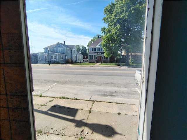 view of road featuring sidewalks, curbs, and a residential view
