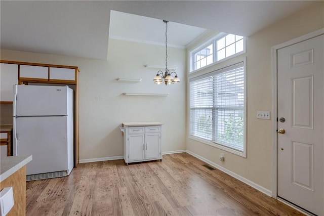 206 SW Chartwell Dr, Lees Summit, MO 64082 - kitchen with freestanding refrigerator, a chandelier, plenty of natural light, light wood-style flooring, and crown molding