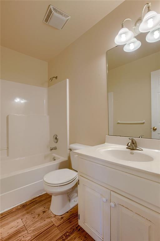 206 SW Chartwell Dr, Lees Summit, MO 64082 - full bathroom featuring wood finished floors, toilet, vanity, and bathtub / shower combination