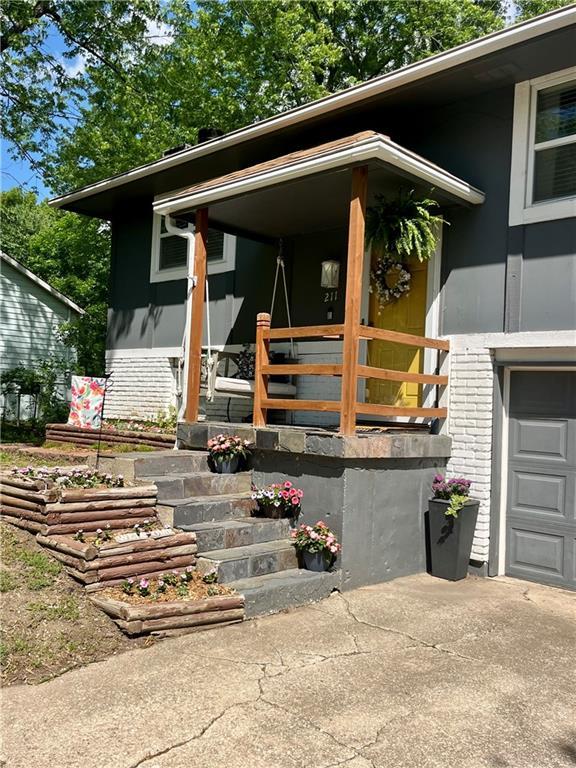 view of exterior entry with brick siding, driveway, and a garage