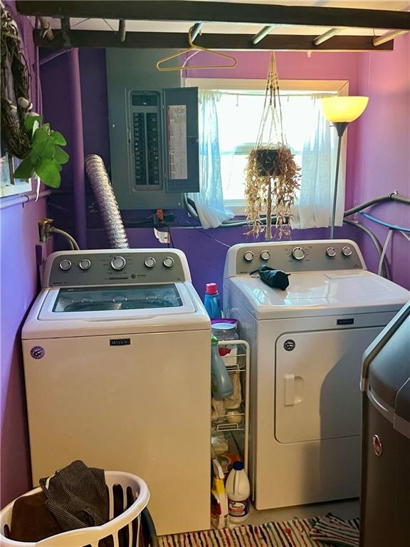 clothes washing area featuring electric panel and washing machine and dryer