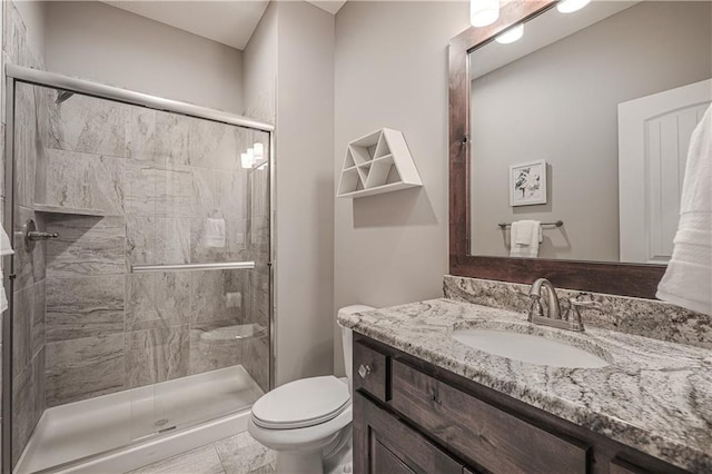 full bath featuring toilet, a shower stall, and vanity