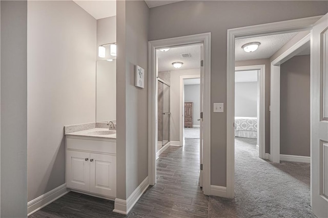 full bathroom featuring vanity, a shower stall, and baseboards