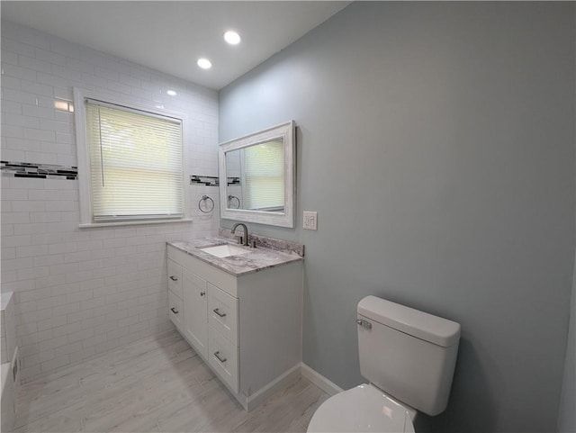 bathroom with toilet, wood finished floors, and vanity