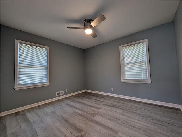 unfurnished room featuring wood finished floors, ceiling fan, and baseboards