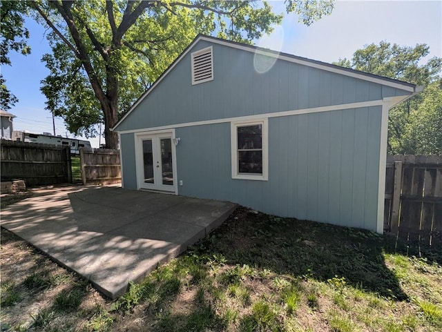 rear view of property with french doors, a fenced backyard, and a patio