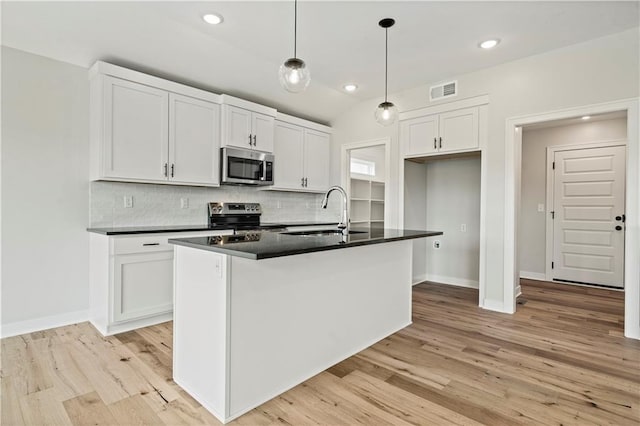 1925 SW Merryman Dr, Lees Summit, MO 64082 - kitchen with stainless steel appliances, a sink, dark countertops, backsplash, and light wood-style floors