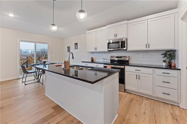 1925 SW Merryman Dr, Lees Summit, MO 64082 - kitchen featuring appliances with stainless steel finishes, a sink, decorative backsplash, light wood-style floors, and dark countertops
