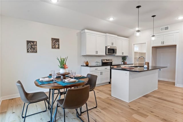 1925 SW Merryman Dr, Lees Summit, MO 64082 - kitchen featuring stainless steel appliances, a sink, dark countertops, tasteful backsplash, and baseboards