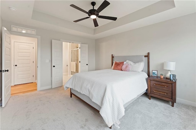 1925 SW Merryman Dr, Lees Summit, MO 64082 - bedroom with a tray ceiling, light carpet, baseboards, ensuite bath, and ceiling fan