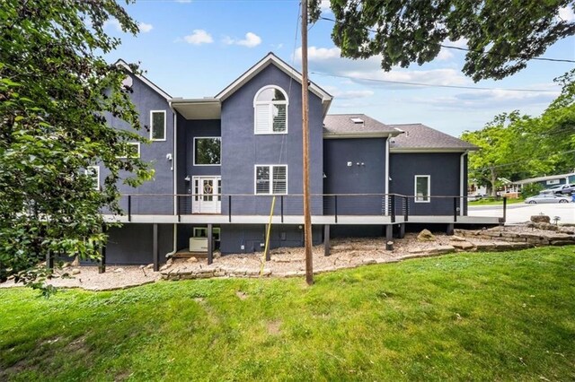 19P Lake Shore Dr, Lake Lotawana, MO 64086 - back of house with a lawn, stucco siding, and a wooden deck