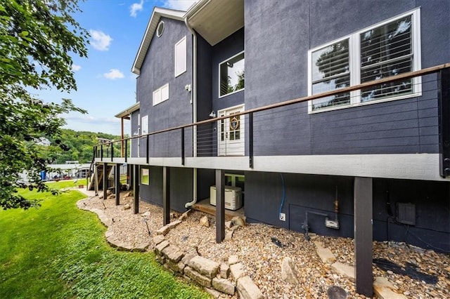19P Lake Shore Dr, Lake Lotawana, MO 64086 - rear view of house featuring stucco siding and a lawn