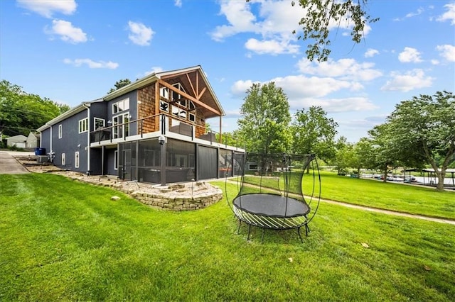 19P Lake Shore Dr, Lake Lotawana, MO 64086 - rear view of property featuring a trampoline, a lawn, and a balcony