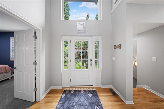 19P Lake Shore Dr, Lake Lotawana, MO 64086 - entrance foyer featuring healthy amount of natural light, a towering ceiling, and light wood-type flooring