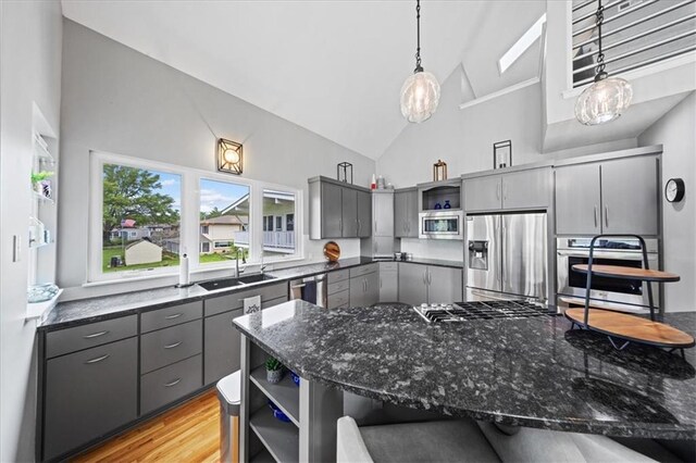 19P Lake Shore Dr, Lake Lotawana, MO 64086 - kitchen with stainless steel appliances, gray cabinets, open shelves, high vaulted ceiling, and dark stone countertops