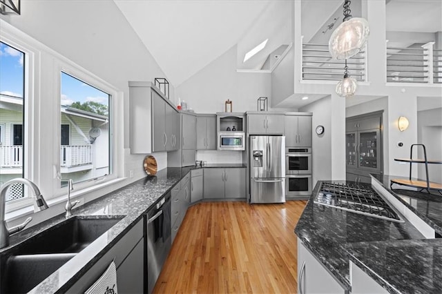 19P Lake Shore Dr, Lake Lotawana, MO 64086 - kitchen with appliances with stainless steel finishes, gray cabinets, high vaulted ceiling, light wood-type flooring, and open shelves