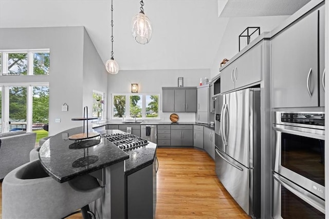 19P Lake Shore Dr, Lake Lotawana, MO 64086 - kitchen with stainless steel appliances, gray cabinets, high vaulted ceiling, healthy amount of natural light, and a breakfast bar