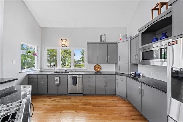 19P Lake Shore Dr, Lake Lotawana, MO 64086 - kitchen with appliances with stainless steel finishes, gray cabinetry, plenty of natural light, lofted ceiling, and dark stone countertops