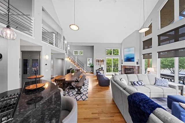 19P Lake Shore Dr, Lake Lotawana, MO 64086 - living area with high vaulted ceiling, stairway, light wood-style floors, healthy amount of natural light, and a glass covered fireplace