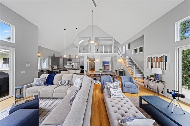 19P Lake Shore Dr, Lake Lotawana, MO 64086 - living area with high vaulted ceiling, wood finished floors, stairway, and a ceiling fan
