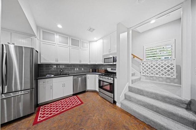 19P Lake Shore Dr, Lake Lotawana, MO 64086 - kitchen featuring stainless steel appliances, dark countertops, white cabinetry, backsplash, and recessed lighting