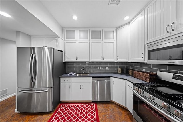 19P Lake Shore Dr, Lake Lotawana, MO 64086 - kitchen featuring appliances with stainless steel finishes, dark countertops, white cabinetry, decorative backsplash, and recessed lighting