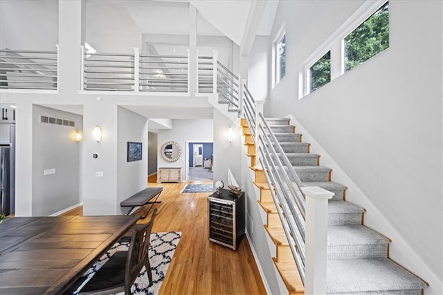 19P Lake Shore Dr, Lake Lotawana, MO 64086 - stairway with a high ceiling, wine cooler, and wood finished floors