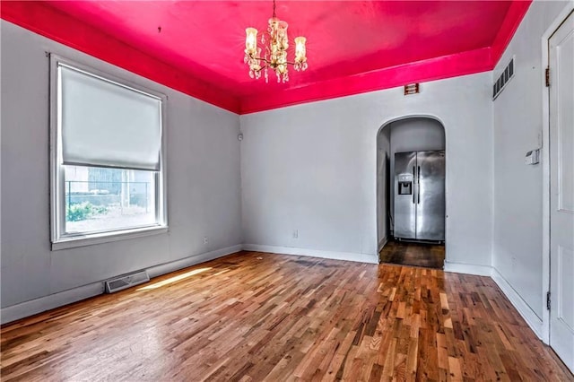 218 S 8th St, Kansas City, KS 66101 - spare room featuring arched walkways, wood finished floors, a chandelier, and baseboards