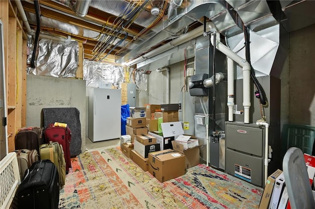 below grade area featuring electric panel and freestanding refrigerator
