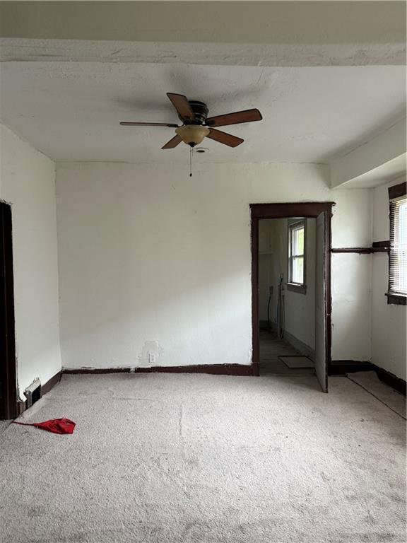 2735 Askew Ave, Kansas City, MO 64128 - spare room featuring light colored carpet, plenty of natural light, and a ceiling fan