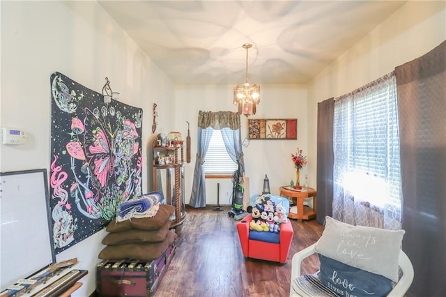 sitting room featuring a chandelier and wood finished floors