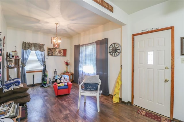 entrance foyer with a chandelier, wood finished floors, and baseboards