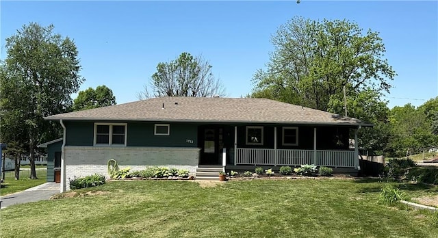 view of front of home featuring covered porch, brick siding, and a front lawn