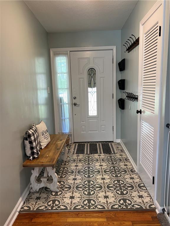 foyer entrance with baseboards and wood finished floors