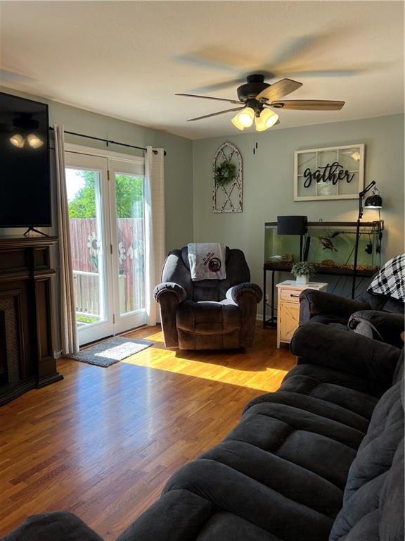 living area with light wood-style flooring and ceiling fan