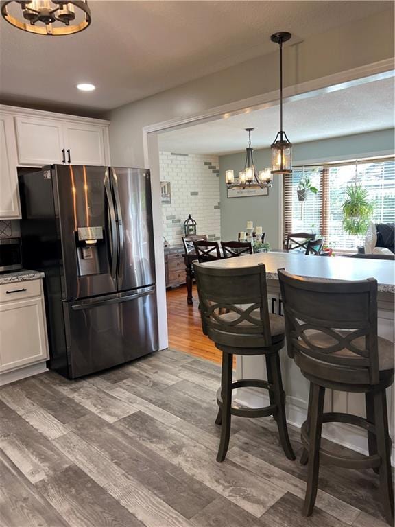 kitchen featuring appliances with stainless steel finishes, a chandelier, white cabinetry, backsplash, and recessed lighting