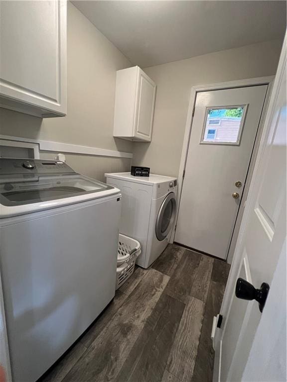 clothes washing area with washer and clothes dryer, cabinet space, and dark wood-type flooring