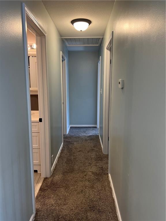 hallway with carpet flooring and baseboards