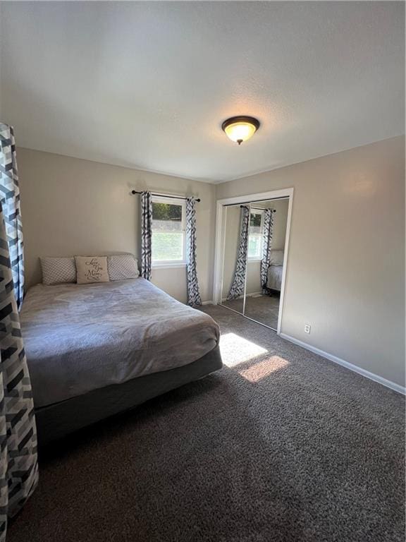 carpeted bedroom featuring baseboards and a closet