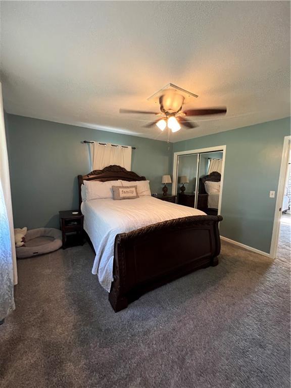 bedroom with a closet, carpet flooring, a ceiling fan, and baseboards